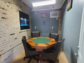 Relax in this stylish room with a hexagonal table and six comfortable chairs, a mounted TV, and a convenient air conditioning unit.
