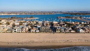 Un pueblo costero con playa, puerto deportivo y edificios residenciales.