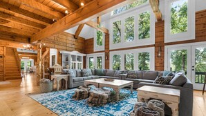 A spacious living room with a large gray sectional sofa, a coffee table, and a patterned rug. - Private Retreat with Majestic Views - Just 15 Minutes from Branson (Saddlebrooke(Chestnutridge))