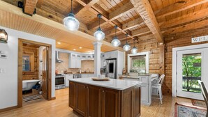 A spacious kitchen with wooden cabinets, a large island, and pendant lighting. - Private Retreat with Majestic Views - Just 15 Minutes from Branson (Saddlebrooke(Chestnutridge))