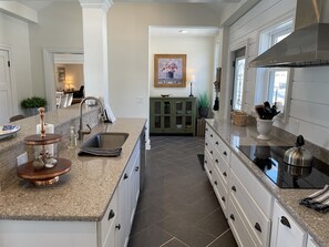 A modern kitchen with granite countertops, stainless steel appliances, and a central island.