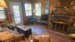 Een gezellige woonkamer met een open haard, houten meubels en een televisie.