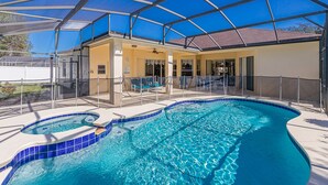 A covered swimming pool with a sunshade, lounge chairs, and a hot tub. - Large executive 4 Bed Villa w/pool & spa, set in peaceful community. Near WDW (Davenport)
