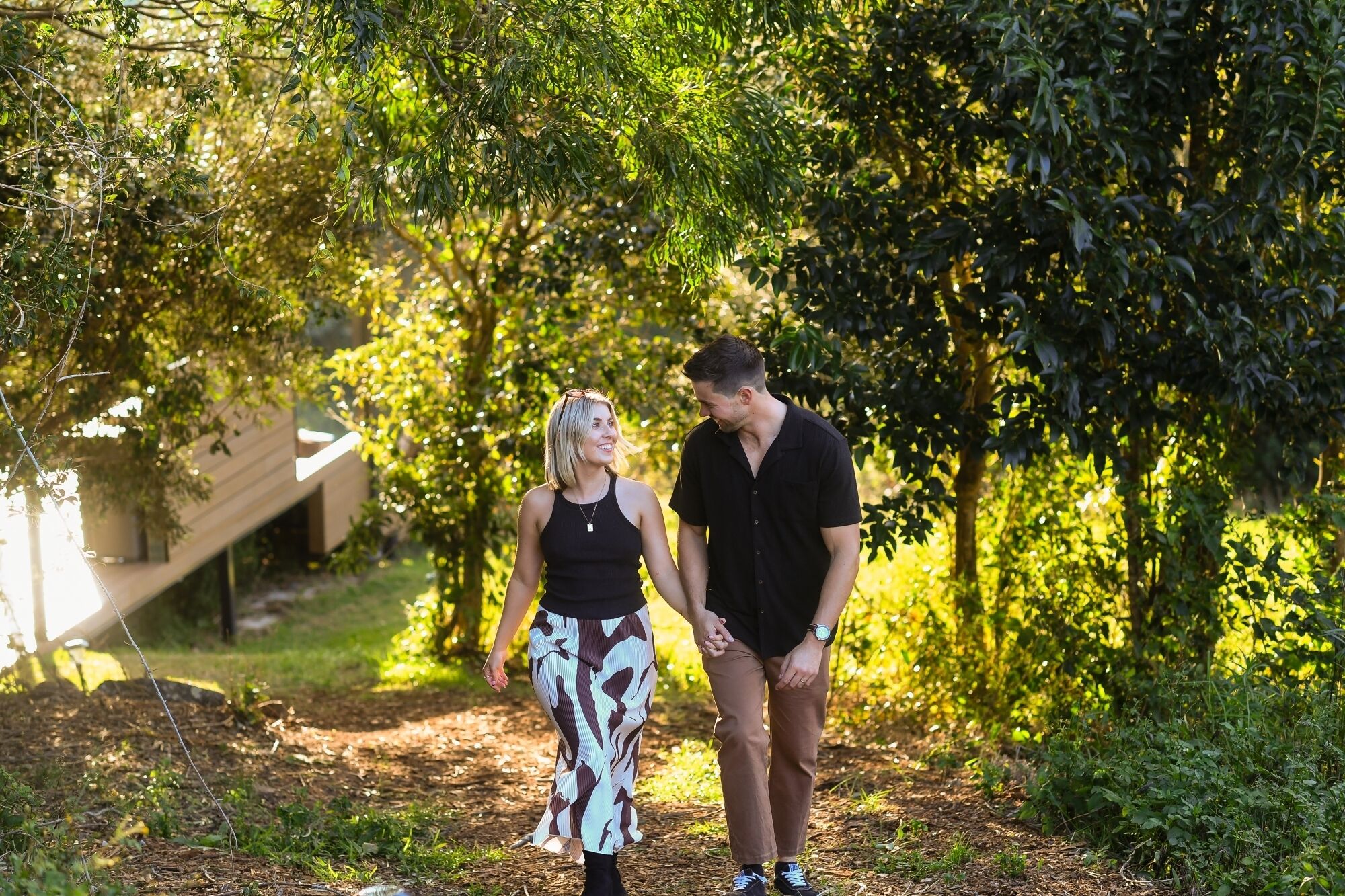 Un couple se promène sur un sentier bordé d’arbres.