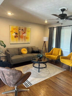 Relax in this stylish living room with a sofa, coffee table, and two armchairs.