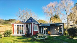 Et toetagers hus med rødt og blåt ydre, en overdækket terrasse og et lille haveareal.