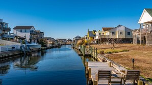 Un canal bordé de quais et de bancs en bois, entouré d’immeubles d’habitation dotés de balcons et offrant une vue sur le canal.