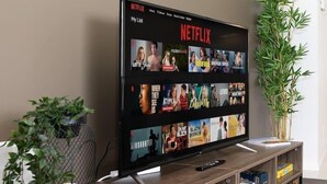 A flat-screen TV mounted on a wooden stand displaying a Netflix interface with various shows. - HighFloor Family Suite 3BD Amazing Views (Brisbane)