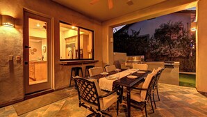 An outdoor patio with a dining table and chairs, a ceiling fan, and a barbecue grill. - Casa Buena—Luxurious Retreat w/2 Masters & Views! (Phoenix)