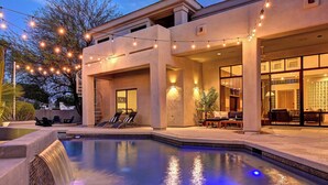 A pool with a waterfall feature, outdoor seating, and string lights. - Casa Buena—Luxurious Retreat w/2 Masters & Views! (Phoenix)