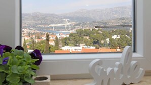 Blick aus dem Fenster auf eine Küstenstadt mit einer Brücke, Bergen und einer 'Smile'-Dekoration.