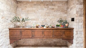 A stone-walled kitchen with a wooden countertop and cabinets. - Charming 5BDR Hacienda w/ Pool, Fire Pit, Billiards | La Casona by AvantStay (Phoenix)