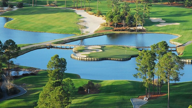 A golf course with water hazards, sand bunkers, and a bridge.