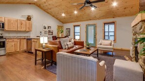 A spacious living room with a wooden ceiling, a fireplace, and a stone accent wall. - High Johnny’s Hideout • Private Hot Tub Retreat (Sevierville)