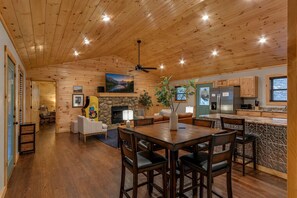 A wooden interior with a dining area, kitchen, and living room.