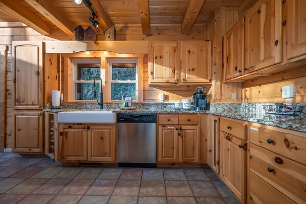 Kitchen features a granite countertop, sink, and window, with a dishwasher and coffee maker.