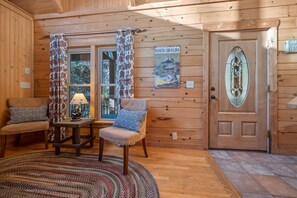 Relax in a cozy room with a comfortable seating area, reading nook, and large window offering a view of the outdoors.