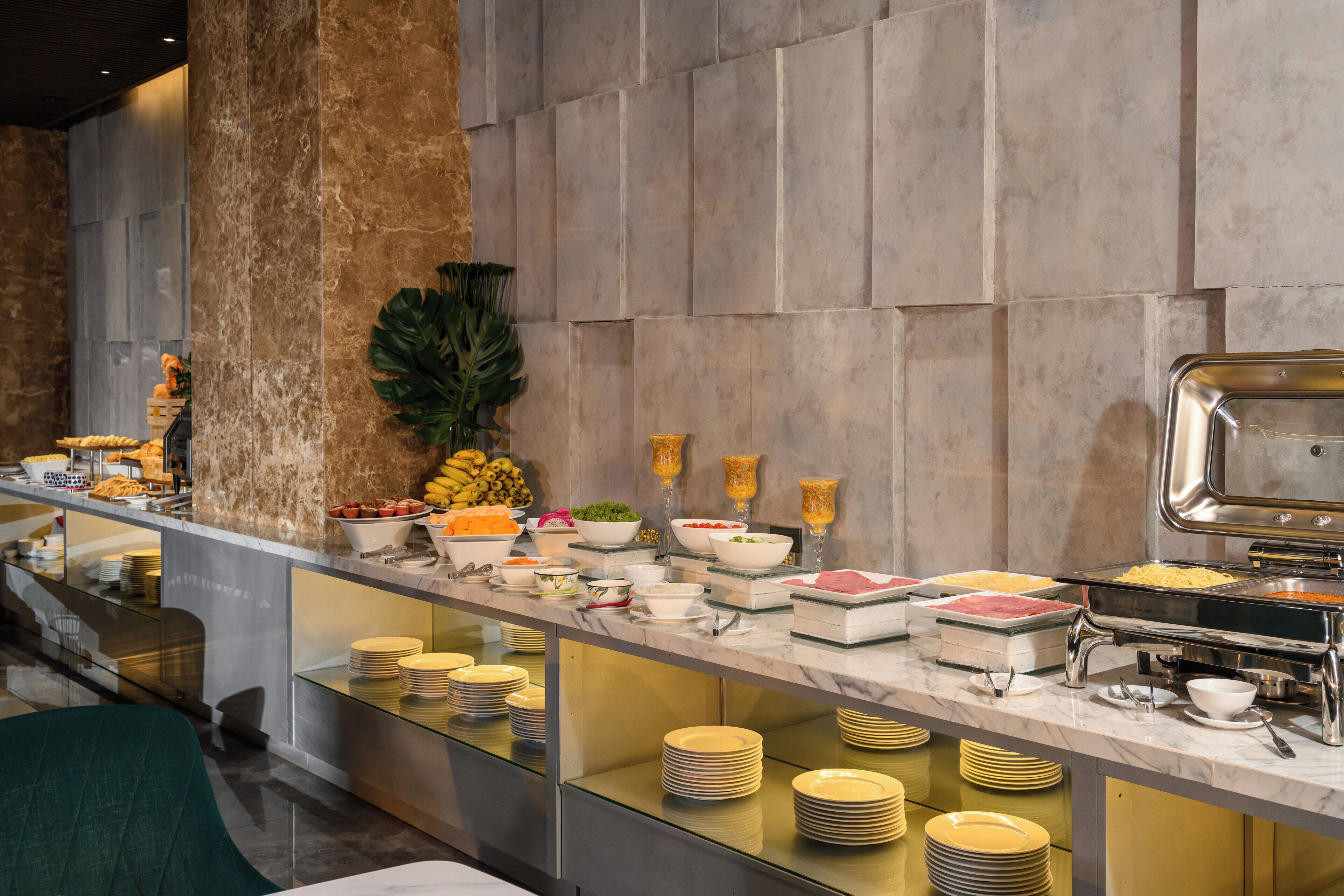 A buffet setup with various food items and dishes.