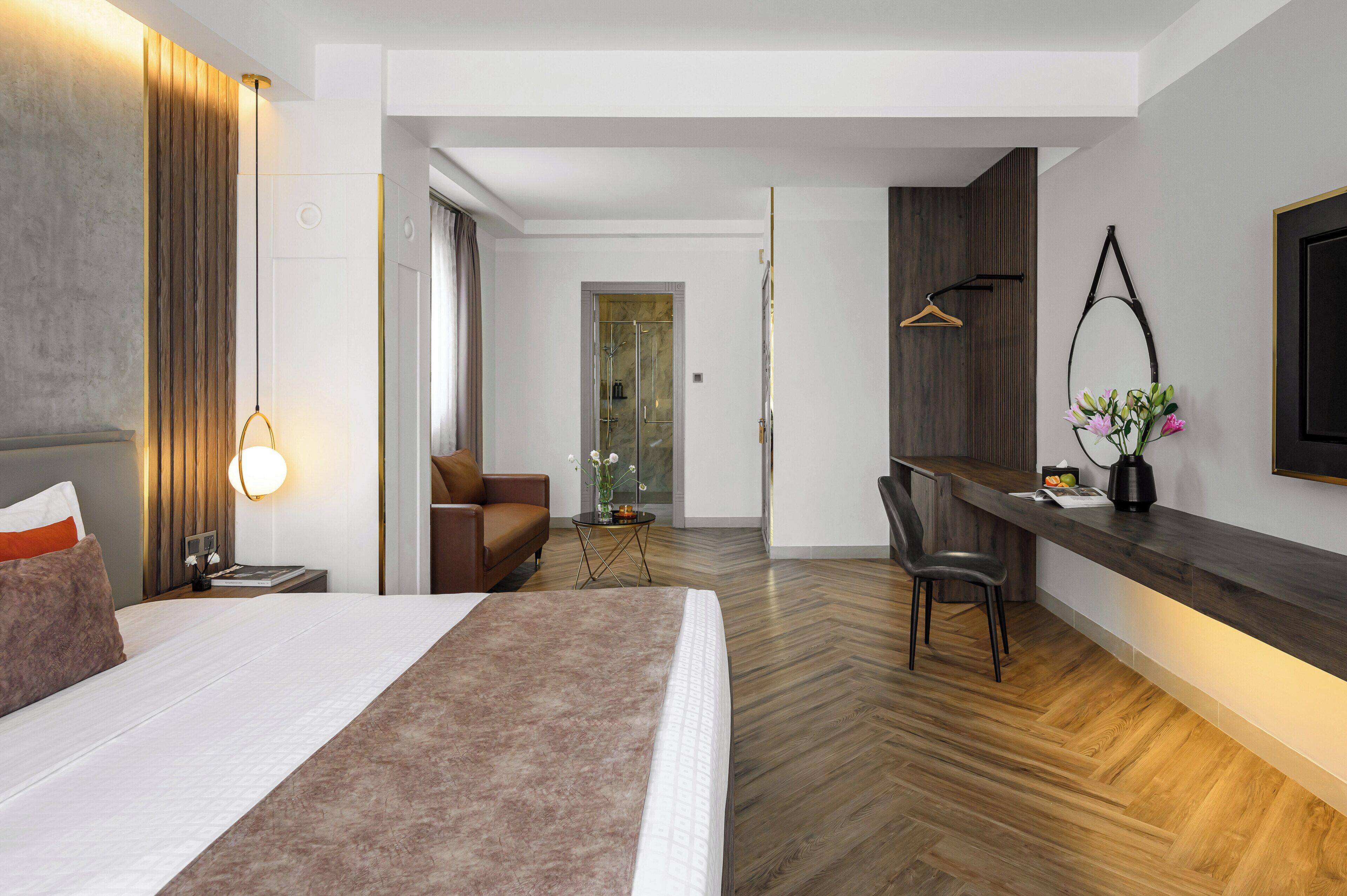 Ein modernes Hotelzimmer mit einem großen Bett, einem Schreibtisch und einer Sitzecke.