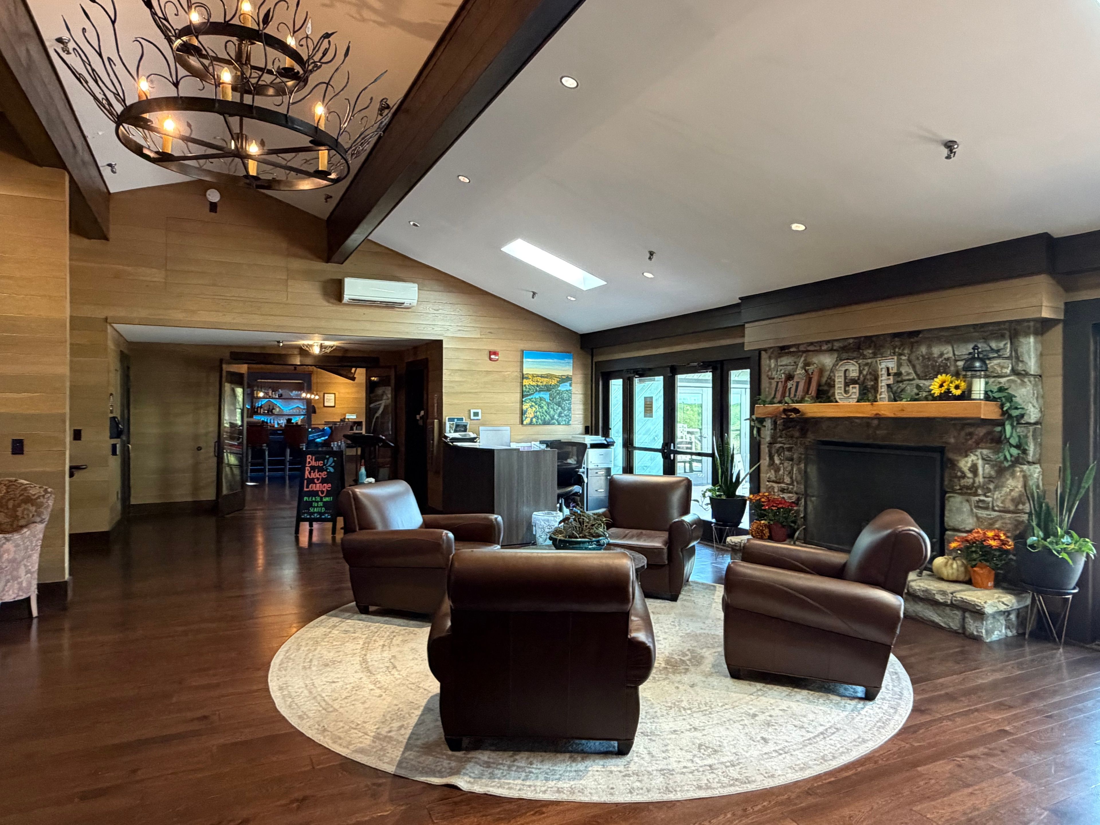 Eine geräumige Lobby mit Ledersofas, einem Kamin und einer Kristallleuchter.