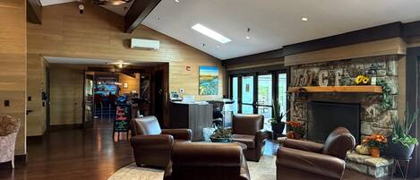 A spacious lobby with leather sofas, a fireplace, and a chandelier.