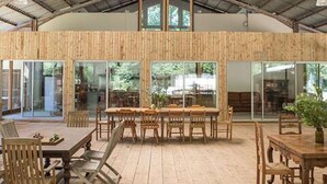 Une pièce spacieuse avec un plafond haut, un plancher en bois et de grandes fenêtres qui laissent entrer la lumière naturelle.