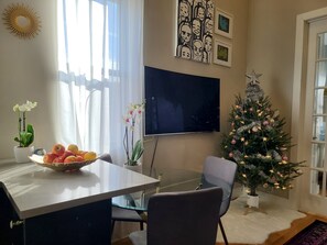 Cozy living space with a dining area, flat-screen TV, and decorative touches.