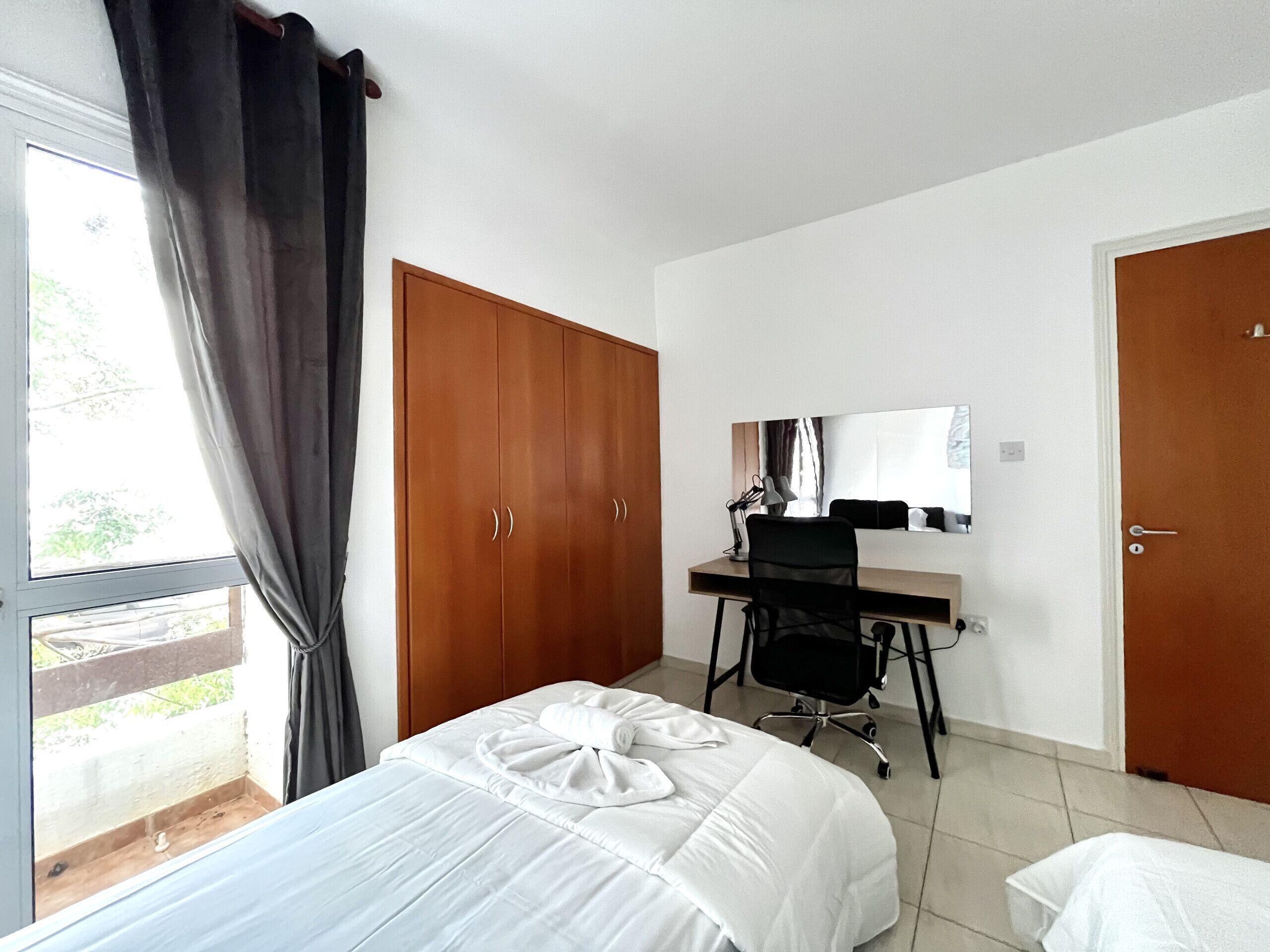 Une chambre d’hôtel comprenant un lit, un bureau avec une chaise, une armoire et une porte.
