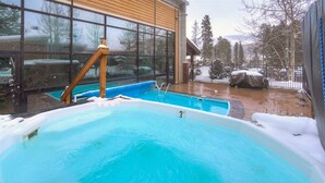 A hot tub area with a wooden deck and a glass wall. - 3bd_cj_12 (Breckenridge)