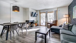 A modern living room with a fireplace, a dining area, and a sofa. - 3bd_cj_12 (Breckenridge)