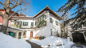 A two-story house with a snow-covered driveway and a visible garage door. - Le Meublè near the train station, close to Ski shuttle bus, Bardonecchia, Italy (Bardonecchia)