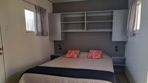 A bedroom with a bed, bedside tables, a wardrobe, and a window with curtains. - COCOBOX (Los Organos)