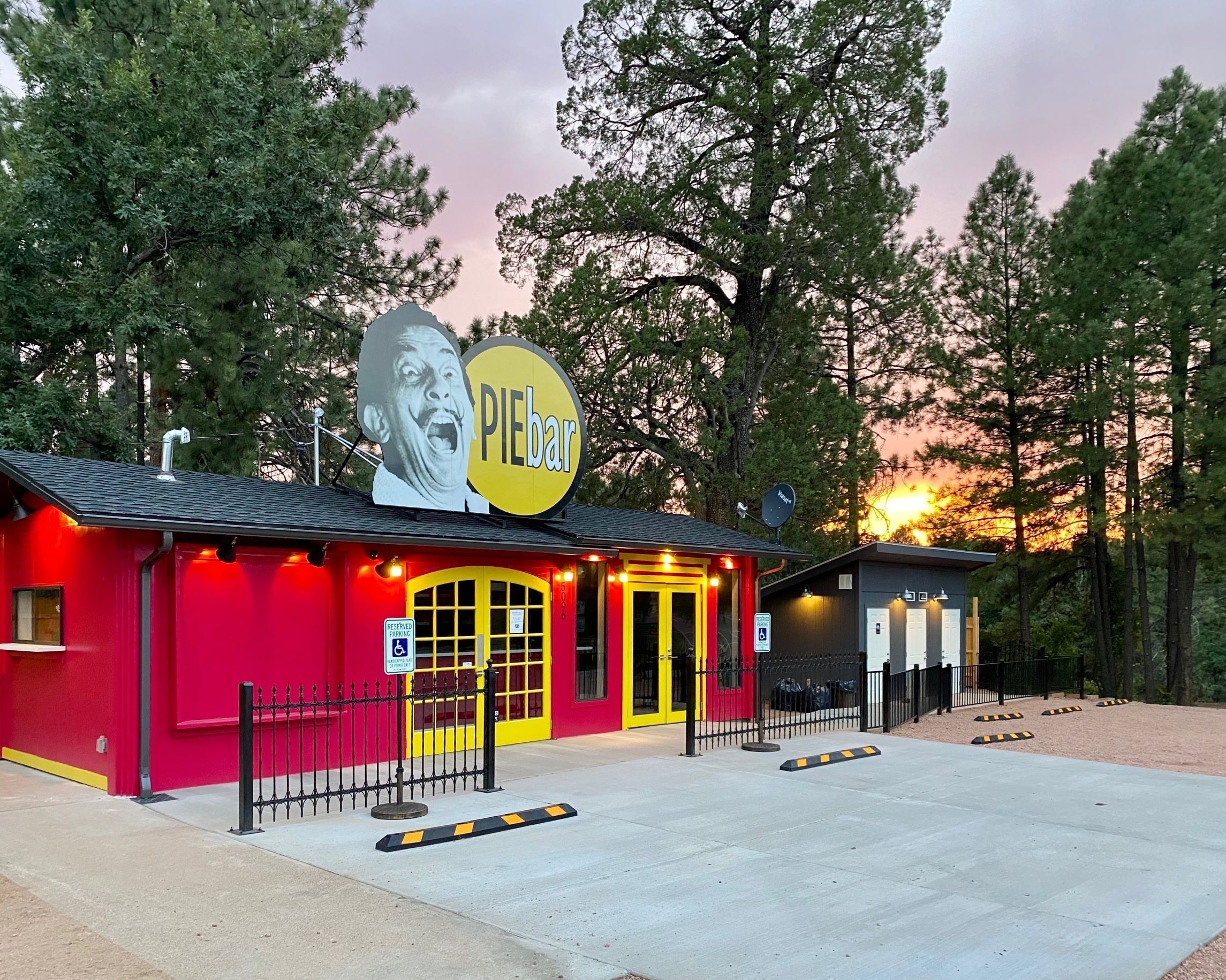 A small, brightly colored building with a sign reading "PIEbar" and a wheelchair accessibility sign.