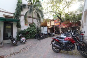 Una calle pavimentada con motocicletas estacionadas y un bar.