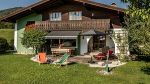 A wooden house with a balcony, a covered patio, and outdoor seating. - Vacation home for up to 10 people with 4 bedrooms, 210m², large garden (Inzell)
