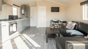 A modern apartment with a kitchen, dining area, and living room. - 1 bedroom accommodation in Kilwinning (Kilwinning)