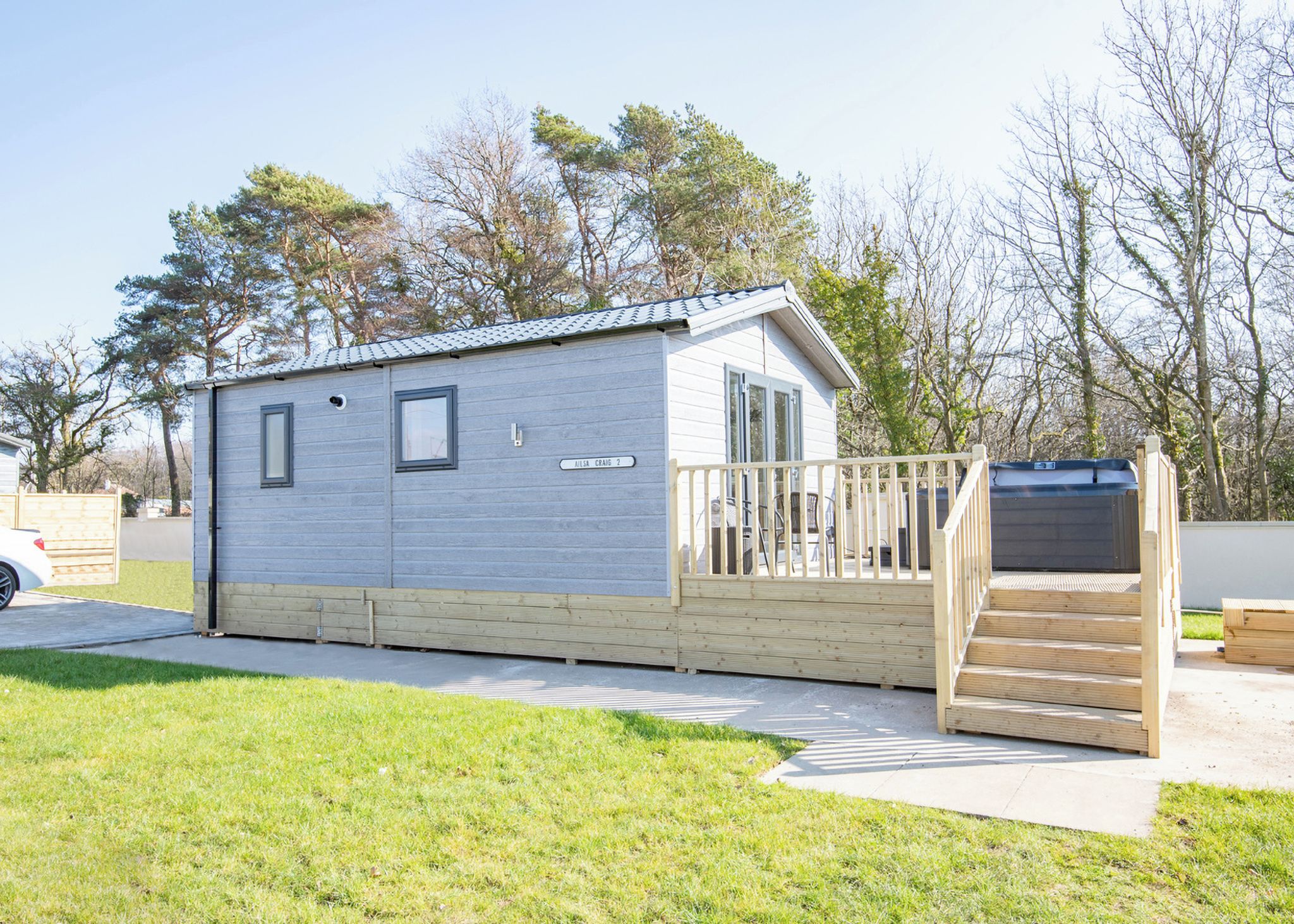 A mobile home with a small deck and a covered outdoor area.