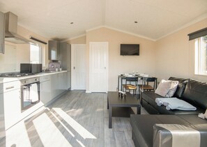 Un appartement moderne comprenant une cuisine, un coin repas et un salon.