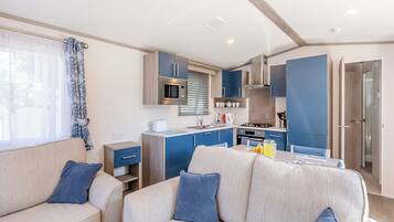 A compact living space with a kitchenette, a sofa, and a dining table.