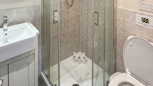 A modern bathroom with a glass-enclosed shower, a white sink, and a toilet. - 1 bedroom accommodation in Naburn, York (Naburn, York)