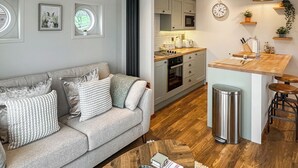 A modern kitchen with a central island, a dining area with a sofa, and a living room with a coffee table. - 1 bedroom accommodation in Naburn, York (Naburn, York)