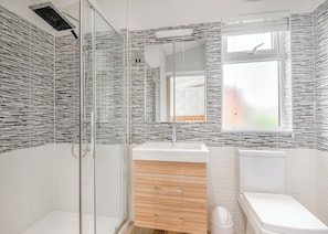A modern bathroom with a glass shower enclosure, a wooden vanity, and a toilet. - 2 bedroom accommodation in Albury, Guildford (Albury, Guildford)