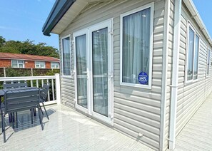 A single-story building with a covered outdoor area, a patio with a table and chairs, and a sign indicating a Golden Anchor membership.