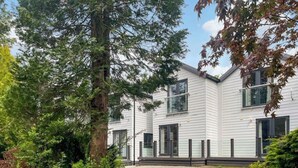 A modern two-story building with a gravel driveway and surrounding greenery. - 3 bedroom accommodation in Milnthorpe (Milnthorpe)