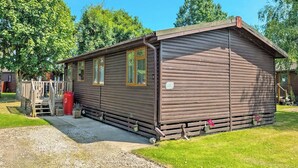 Une cabane en bois avec une véranda, une petite fenêtre et une porte.