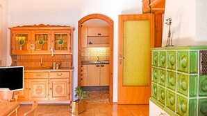 Eine Küche mit Holzausstattung, einem grünen Gerät und einer gefliesten Spritzschutzwand.