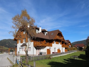 Un edificio de estilo chalete tradicional con fachada de madera, ventanas amplias y un balcón.