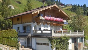 A two-story chalet with a balcony, a garage, and a stone staircase leading to the entrance. - Apartment in Hollersbach near Kitzbühel ski lift (Hollersbach im Pinzgau)