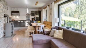 Une cuisine moderne avec un coin repas et un espace salon confortable offrant une vue sur l’extérieur.