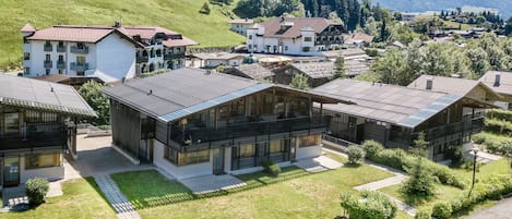 Un barrio residencial con casas modernas, un camino pavimentado y vistas despejadas de las colinas circundantes.